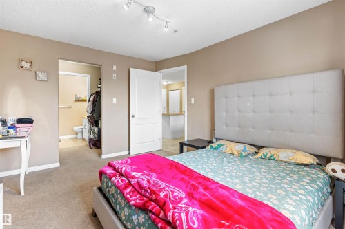 The property features a bedroom with light brown walls and carpeted flooring - 224 3425 19 Street Nw, Edmonton, AB - Indoor Photo Showing Bedroom