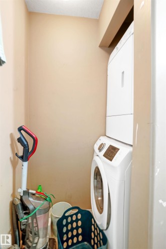 Dedicated laundry area featuring a white stacked washer and dryer - 224 3425 19 Street Nw, Edmonton, AB - Indoor Photo Showing Laundry Room