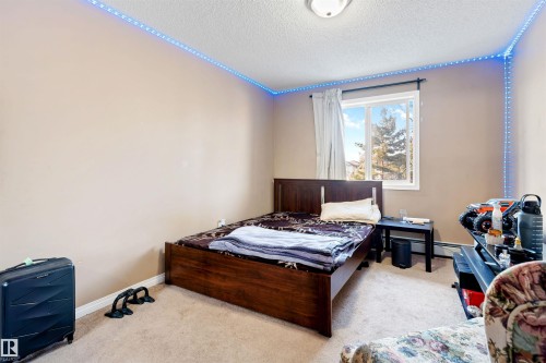 The room features a window providing natural light, carpeted flooring, and a ceiling light fixture - 224 3425 19 Street Nw, Edmonton, AB - Indoor Photo Showing Bedroom