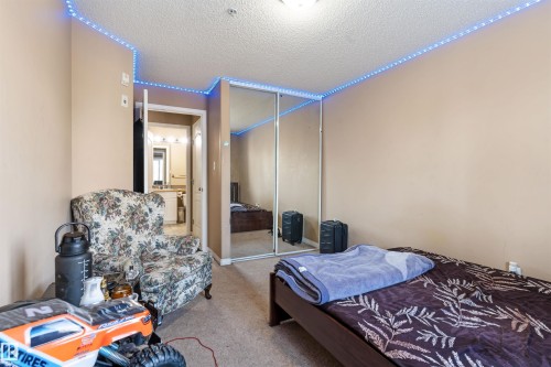 The room features neutral-toned walls, carpeted flooring, and a mirrored closet - 224 3425 19 Street Nw, Edmonton, AB - Indoor Photo Showing Bedroom