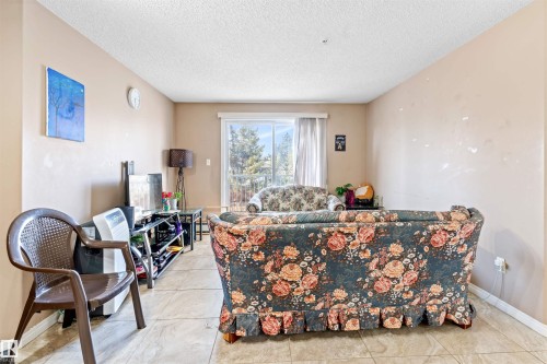 Living area featuring light beige walls, a white ceiling, and tiled flooring - 224 3425 19 Street Nw, Edmonton, AB - Indoor