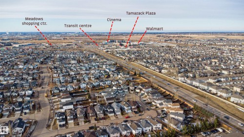 Aerial view showcasing the surrounding neighborhood with residential properties, a multi-lane highway, and commercial amenities including a shopping center, transit center, cinema, and retail plaza - 224 3425 19 Street Nw, Edmonton, AB - Outdoor With View