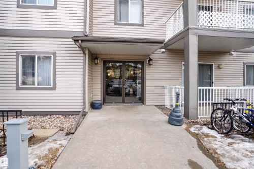 The property features a concrete walkway leading to the main entrance, which includes double glass doors - 224 3425 19 Street Nw, Edmonton, AB - Outdoor With Exterior