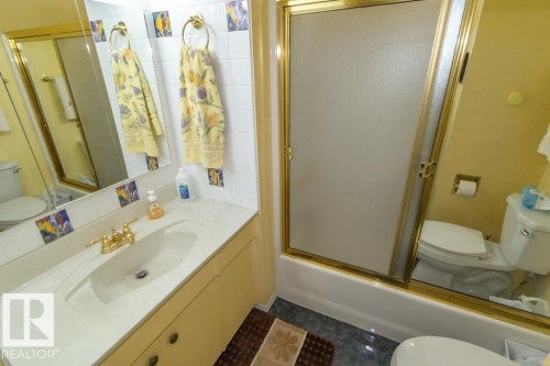 The property features a bathroom with a shower-tub combination, a vanity with a single sink, and a toilet - 5013 45 St, St. Paul Town, AB - Indoor Photo Showing Bathroom