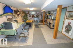 This room features carpeted flooring, exposed wooden support beams, and recessed lighting - 
