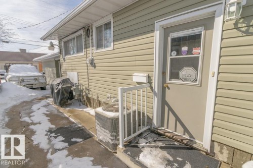 The property features beige siding, an exterior door with a window, and a white handrail leading to the entrance - 5013 45 St, St. Paul Town, AB - Outdoor With Exterior
