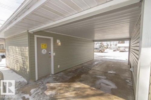 The property includes a covered carport with a concrete slab and a side entrance to the building - 5013 45 St, St. Paul Town, AB -  With Exterior