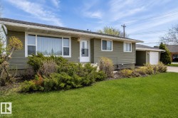 Ranch-style exterior with olive green siding, white trim, and a dark shingle roof - 