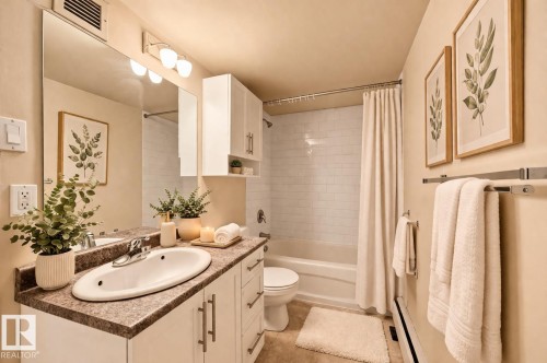 Bathroom featuring a vanity with a countertop and sink, a mirror with overhead lighting, and a shower with a shower curtain - virtual staging - 209 9710 105 Street Nw, Edmonton, AB - Indoor Photo Showing Bathroom
