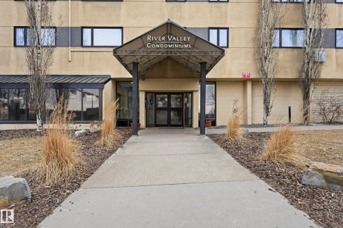 The property features a concrete walkway leading to an entryway with an overhead canopy - 209 9710 105 Street Nw, Edmonton, AB - Outdoor