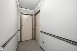 This photo captures a hallway with light-colored walls and crown molding - 