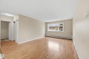 The property features light-colored walls, wood-style flooring, and a window providing views of the outdoors - 209 9710 105 Street Nw, Edmonton, AB  - Indoor 