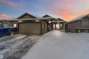 The property features a two-car garage, a covered front porch, and a stone facade detail - 61 Linkside Blvd, Spruce Grove, AB  - Outdoor With Facade 