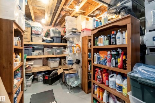 The property features an unfinished utility room with exposed ceiling joists and ductwork, illuminated by overhead lighting - 61 Linkside Blvd, Spruce Grove, AB - Indoor