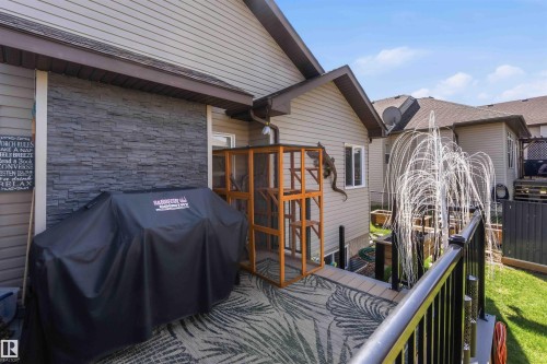 Multi-level deck featuring a patterned outdoor rug, black metal railings, and a water feature - 61 Linkside Blvd, Spruce Grove, AB - Outdoor With Deck Patio Veranda
