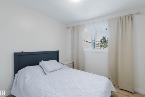 This bedroom features light-colored walls and flooring, with a window providing natural light - 18088 93 Avenue Nw, Edmonton, AB - Indoor Photo Showing Bedroom