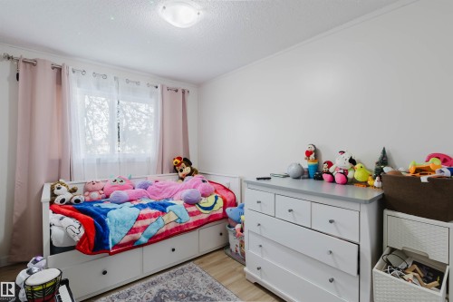 This room features a window with light-colored curtains, a ceiling light fixture, and light-colored walls - 18088 93 Avenue Nw, Edmonton, AB - Indoor Photo Showing Bedroom