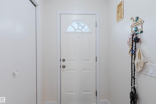 The property features a white paneled door with an arched window, complemented by a white closet door with horizontal detailing - 18088 93 Avenue Nw, Edmonton, AB - Indoor Photo Showing Other Room