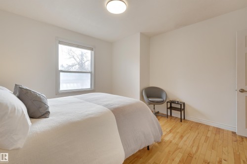 The room features light-toned hardwood flooring and a ceiling-mounted light fixture - 10940 71 Avenue, Edmonton, AB - Indoor Photo Showing Bedroom