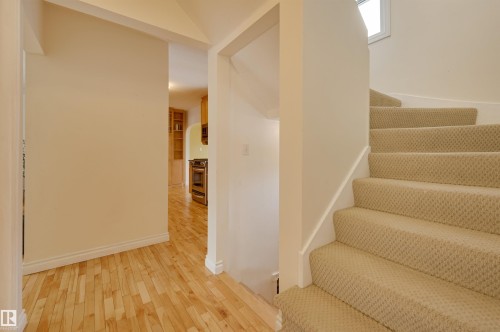The property features hardwood flooring and a carpeted staircase - 10940 71 Avenue, Edmonton, AB - Indoor Photo Showing Other Room