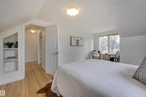 Bright room featuring light hardwood floors, built-in shelving, and a window providing natural light - 10940 71 Avenue, Edmonton, AB - Indoor Photo Showing Bedroom