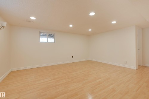 Spacious room featuring light wood flooring, white walls, recessed ceiling lights, and a window for natural light - 10940 71 Avenue, Edmonton, AB - Indoor Photo Showing Other Room