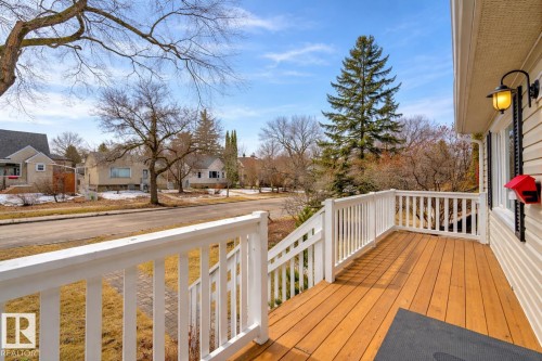The property features an outdoor deck with a wood surface and white railings, offering views of the surrounding neighborhood - 10940 71 Avenue, Edmonton, AB - Outdoor With Deck Patio Veranda