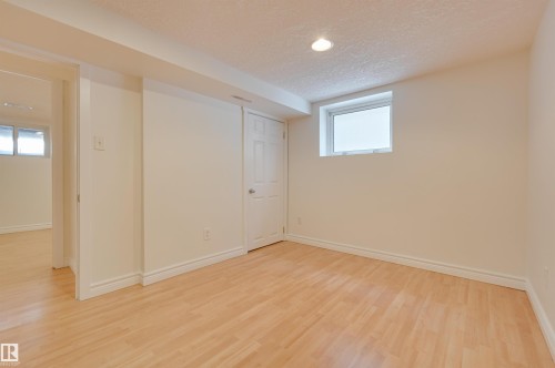 Bright and open room featuring light wood flooring, white walls, and an overhead light fixture - 10940 71 Avenue, Edmonton, AB - Indoor Photo Showing Other Room