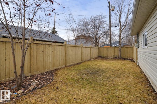 The property features a fenced yard with a lawn and a tree - 10940 71 Avenue, Edmonton, AB - Outdoor