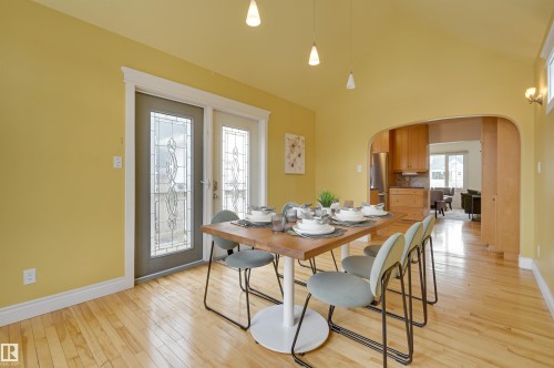 Dining area featuring hardwood floors, a vaulted ceiling, and decorative glass doors - 10940 71 Avenue, Edmonton, AB - Indoor Photo Showing Dining Room