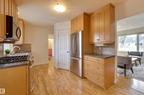 Kitchen featuring light wood cabinetry, stainless steel appliances, and a tiled backsplash - 10940 71 Avenue, Edmonton, AB - Indoor Photo Showing Kitchen