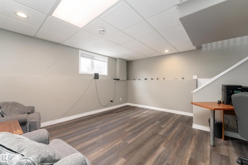 Spacious room featuring durable laminate flooring, a drop ceiling with recessed lighting and a large ceiling light panel, and a window providing natural light - 4403 Yeoman Drive, Onoway, AB - Indoor Photo Showing Other Room