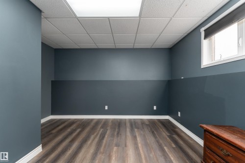 Room featuring modern flooring, blue walls, a window, and overhead lighting - 4403 Yeoman Drive, Onoway, AB - Indoor Photo Showing Other Room