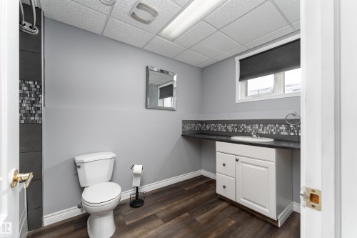 The bathroom features a toilet, a vanity with a sink, and a tiled shower area with a mosaic accent - 4403 Yeoman Drive, Onoway, AB - Indoor Photo Showing Bathroom