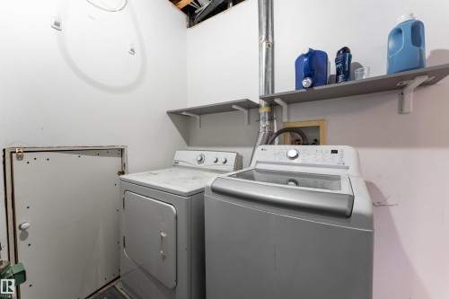 Dedicated laundry space with a washer and dryer, featuring wall-mounted shelving - 4403 Yeoman Drive, Onoway, AB - Indoor Photo Showing Laundry Room