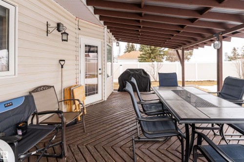 The property features a covered outdoor deck with a wooden floor, providing an expansive area for outdoor enjoyment - 4403 Yeoman Drive, Onoway, AB - Outdoor With Deck Patio Veranda With Exterior