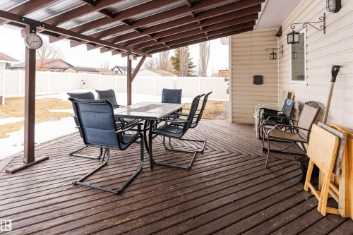The property features a covered wooden deck with a slatted roof, offering an outdoor living space - 4403 Yeoman Drive, Onoway, AB - Outdoor With Deck Patio Veranda With Exterior