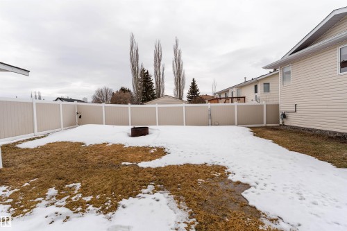 The property features a fenced backyard with a lawn and a fire pit - 4403 Yeoman Drive, Onoway, AB - Outdoor