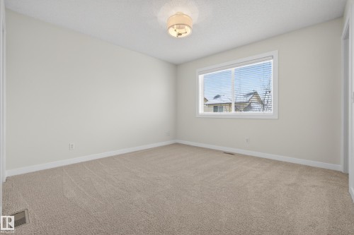 This room features neutral-toned carpet, light-colored walls, and a window with blinds - 9 10909 106 Street, Edmonton, AB - Indoor Photo Showing Other Room