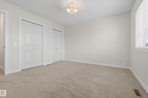This room features light-colored walls and carpeted flooring, creating a neutral canvas - 9 10909 106 Street, Edmonton, AB - Indoor Photo Showing Other Room