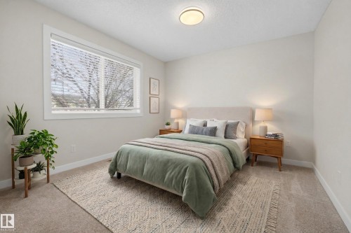 Bedroom featuring neutral wall colors, carpeted floors, and a large window with blinds - 9 10909 106 Street, Edmonton, AB - Indoor Photo Showing Bedroom