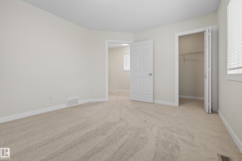 This spacious room features neutral-toned carpeting, light-colored walls, and a window with blinds providing natural light - 9 10909 106 Street, Edmonton, AB - Indoor Photo Showing Other Room