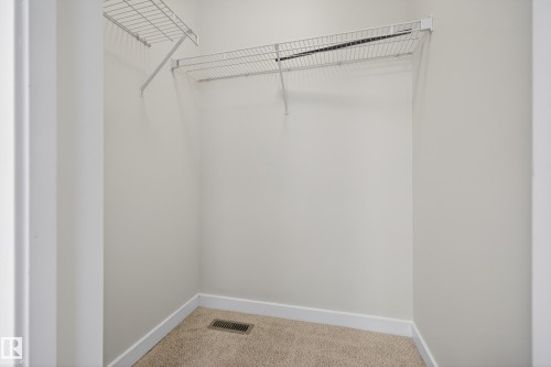 The property features a closet with carpeted flooring and white wire shelving - 9 10909 106 Street, Edmonton, AB - Indoor With Storage