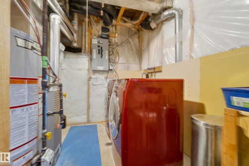 This utility area includes a water heater, furnace, and a washer and dryer - 9 10909 106 Street, Edmonton, AB - Indoor Photo Showing Basement