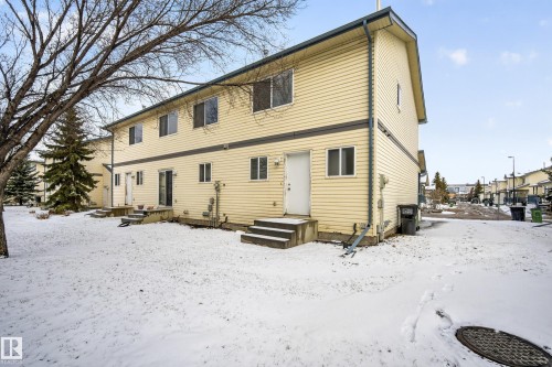 The property features light yellow siding and a dark roof - 9 10909 106 Street, Edmonton, AB - Outdoor