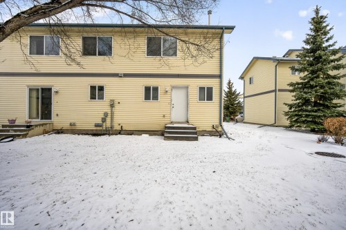 The property features a private yard with a door leading directly to the exterior, and a sliding glass door providing external access - 9 10909 106 Street, Edmonton, AB - Outdoor With Exterior