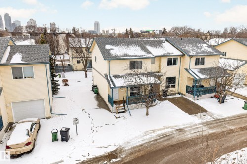 The property features a two-story design with light-colored siding and a dark roof - 9 10909 106 Street, Edmonton, AB - Outdoor
