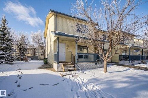 The property features a light-colored exterior with a front porch - 9 10909 106 Street, Edmonton, AB - Outdoor With Facade