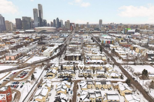 Aerial view of the property and surrounding neighborhood, featuring a winter landscape and distant city skyline - 9 10909 106 Street, Edmonton, AB - Outdoor With View