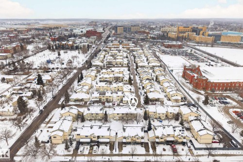 This aerial view showcases a residential area with numerous properties featuring snow-covered rooftops - 9 10909 106 Street, Edmonton, AB - Outdoor With View